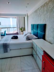 1 dormitorio con 1 cama grande y cabecero azul en RICARDO Pousada - SUITE MASTER, en Vila Velha