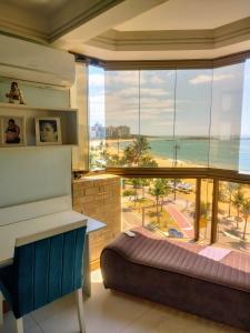 a bedroom with a large window with a view of the ocean at RICARDO Pousada - SUITE MASTER in Vila Velha