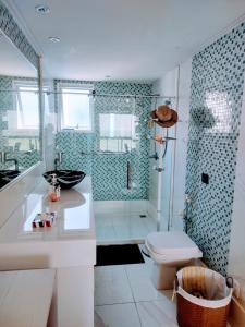 uma casa de banho com um chuveiro, um lavatório e um WC. em RICARDO Pousada - SUITE MASTER em Vila Velha