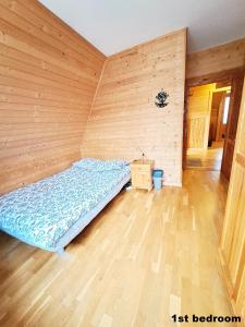 ザコパネにあるPokoje przy Cichej Wodzieの木製の壁のベッドルーム1室