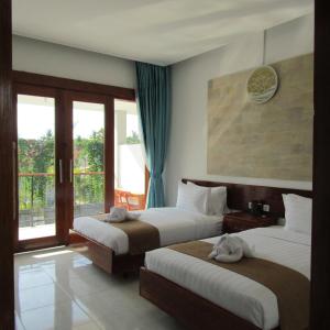 ギリ・アイルにあるDe Padma Gili Airのベッド2台とバルコニーが備わるホテルルームです。