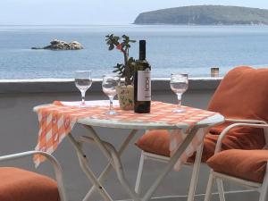 a table with two glasses and a bottle of wine at Nikos Rooms in Nea Peramos