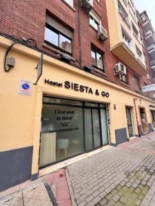una tienda con un cartel en la parte delantera de un edificio en Hostel Siesta & Go (Atocha), en Madrid