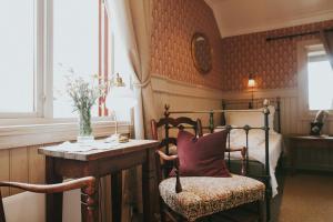 a bedroom with a bed and a table and a chair at Tuddal Høyfjellshotel in Tuddal