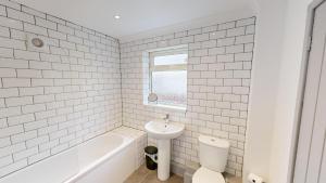 uma casa de banho branca com uma banheira e um lavatório e uma banheira em Stunning City Centre 2024 Refurb em Sunderland