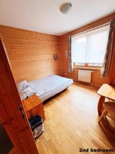 ザコパネにあるPokoje przy Cichej Wodzieの木製の壁のベッドルーム1室(ベッド1台付)
