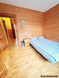 ザコパネにあるPokoje przy Cichej Wodzieの木製の壁のベッドルーム1室