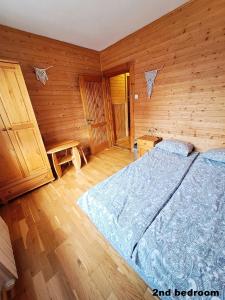 ザコパネにあるPokoje przy Cichej Wodzieの木製の部屋にベッド1台が備わるベッドルーム1室があります。