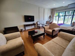 uma sala de estar com um sofá e cadeiras e uma televisão em RT Grace Royal Taj Hotel Sukkur em Kalar Goth