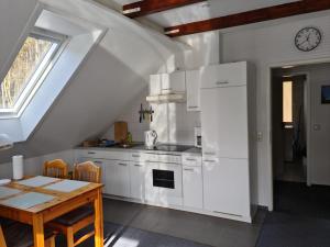 a kitchen with white cabinets and a table and a window at Ferienwohnung Prälank direkt am See in Neustrelitz