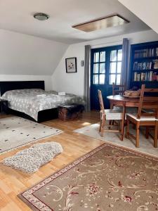1 dormitorio con 1 cama, mesa y sillas en Somlo Wineshop Guesthouse, en Somlóvásárhely