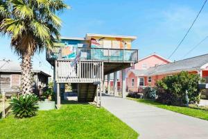 ein Haus mit einem Balkon und einem Baum in der Unterkunft Galveston Beach House Family/Pet Friendly in Galveston