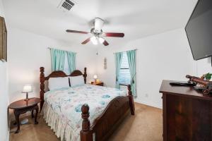 Schlafzimmer mit einem Bett und einem Deckenventilator in der Unterkunft Galveston Beach House Family/Pet Friendly in Galveston