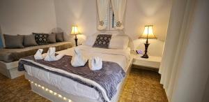 1 dormitorio con 2 camas con zapatos blancos. en Pleasure Seaside Rooms en Perissa