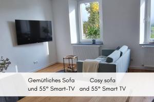 a living room with a couch and a tv at Terrassenidylle in Winzerhaus in Bremm