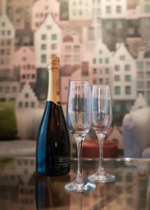 eine Flasche Wein und zwei Weingläser auf dem Tisch in der Unterkunft Apartament Milano in Pniewy