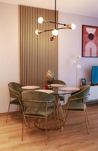 ein Esszimmer mit grünen Stühlen und einem Tisch in der Unterkunft Apartament Milano in Pniewy