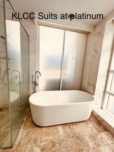 a white bath tub in a bathroom with a shower at KLCC Suites at Platinum in Kuala Lumpur