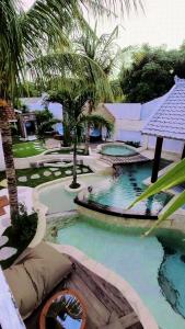 ギリ・トラワンガンにあるThe White Key Luxury Villasのヤシの木が茂るリゾート内のスイミングプール