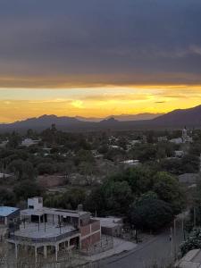 una vista de una ciudad con la puesta de sol en el fondo en Hospedaje Familiar Raza Mistica en Villa Unión