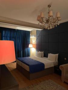 a bedroom with a bed and a chandelier at Sherlock Hotel Baku in Baku
