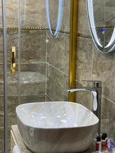 a white sink in a bathroom with a shower at Sherlock Hotel Baku in Baku