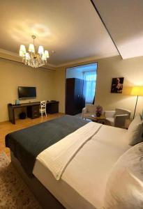 a bedroom with a large bed and a living room at Sherlock Hotel Baku in Baku