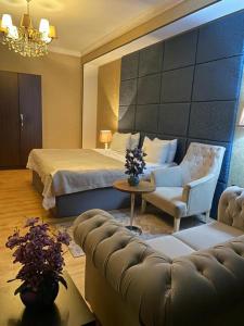 Sherlock Hotel Baku في باكو: غرفه فندقيه بسرير واريكه