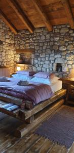 una camera con un grande letto in una parete in pietra di CHALET a Patra