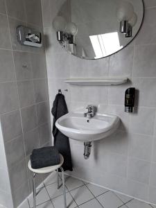 a bathroom with a sink and a mirror and a stool at Pension 3 Ferienhof Hanstorf in Satow