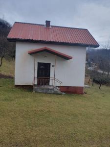 un pequeño edificio blanco con techo rojo en Nikša apartment, en Pljevlja