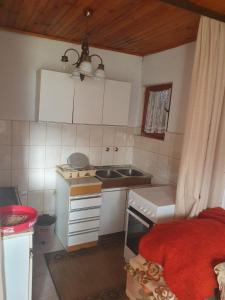 una pequeña cocina con armarios blancos y fregadero en Nikša apartment, en Pljevlja