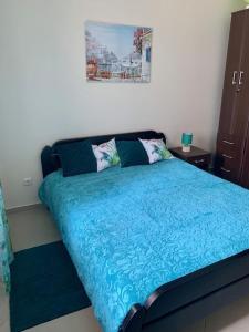 Schlafzimmer mit einem Bett mit blauer Decke in der Unterkunft An artist's dream in Dobrota