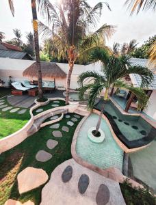 an aerial view of a resort with a swimming pool and palm trees at The White Key Luxury Villas in Gili Trawangan