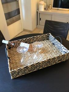 einen Korbkorb mit zwei Weingläsern auf dem Tisch in der Unterkunft Cocon familial avec jardin au cœur de St Servan in Saint-Malo