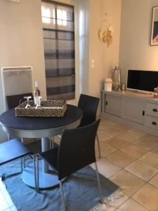 ein Wohnzimmer mit einem Tisch, Stühlen und einem Schreibtisch in der Unterkunft Cocon familial avec jardin au cœur de St Servan in Saint-Malo