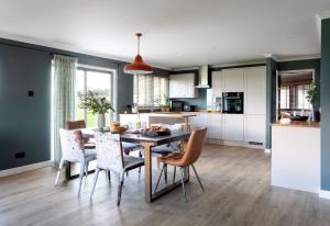 a kitchen and dining room with a table and chairs at Overthickside Cottage in Jedburgh