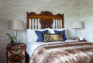 a bedroom with a large bed with two lamps at Overthickside Cottage in Jedburgh