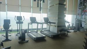 a gym with cardio equipment in front of a large window at The Riviera Monaco in Na Jomtien