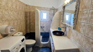 bagno con lavandino, servizi igienici e specchio di Pleasure Seaside Rooms a Perissa