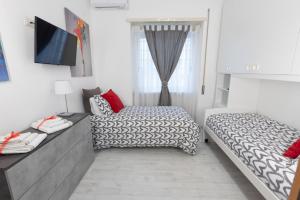 a bedroom with two beds and a television in it at Baglioni Vatican House in Rome