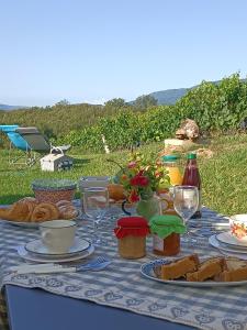 una mesa con platos de comida y copas de vino en Dormire in una botte - Antiche Vigne Pironti, 