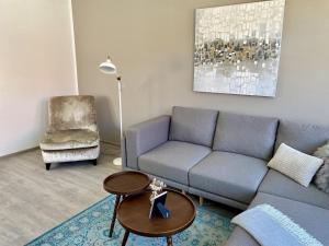 ein Wohnzimmer mit einem Sofa und einem Stuhl in der Unterkunft discovAIR - Eisenach Karl14 - Vollausgestattete Apartments mit Netflix in der Fussgängerzone in Eisenach