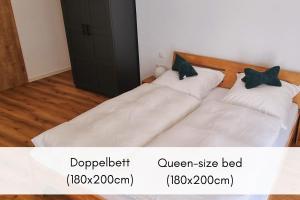 two beds in a room with white sheets at Mosel-Blick: Charme & Komfort in Bremm