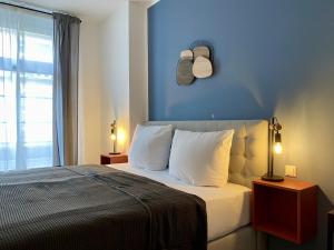 1 dormitorio con 1 cama con pared azul en discovAIR - Eisenach Karl14 - Vollausgestattete Apartments mit Netflix in der Fussgängerzone en Eisenach