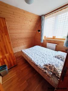 ザコパネにあるPokoje przy Cichej Wodzieの木製の部屋にベッド1台が備わるベッドルーム1室があります。
