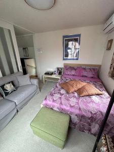 um quarto com uma cama roxa e um sofá em VILLA KUSUNOKI em Tóquio