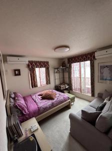um quarto com uma cama roxa e um sofá em VILLA KUSUNOKI em Tóquio
