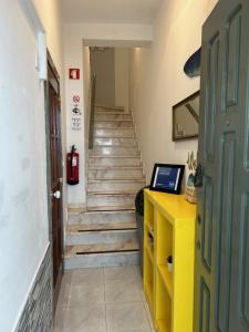 a hallway with stairs and a yellow desk with a laptop at 'ESTRELA STAYS' in Lagos