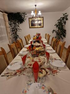 uma mesa longa com pratos e copos de vinho em Pensiunea Ancuta din Botiza em Botiza